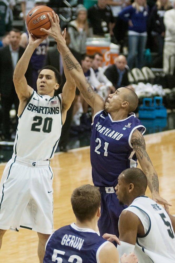 	<p>Junior guard Travis Trice takes a jump shot defended by Portland guard Korey Thieleke on Nov. 18, 2013, at Breslin Center. The Spartans defeated the Pilots, 82-67. Danyelle Morrow/The State News</p>