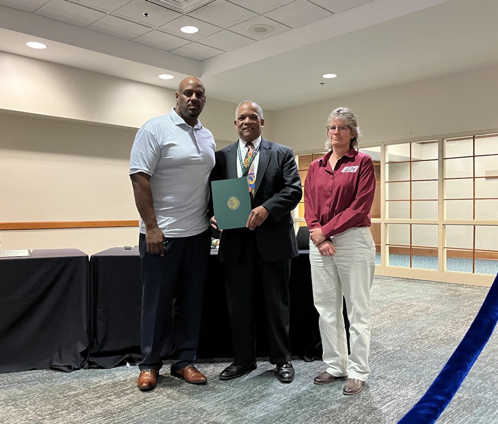 <p>Mayor Ron Bacon presents a resolution honoring first responders to police and fire department chiefs Kim Johnson and Dawn Carson at the May 23 council meeting.</p>