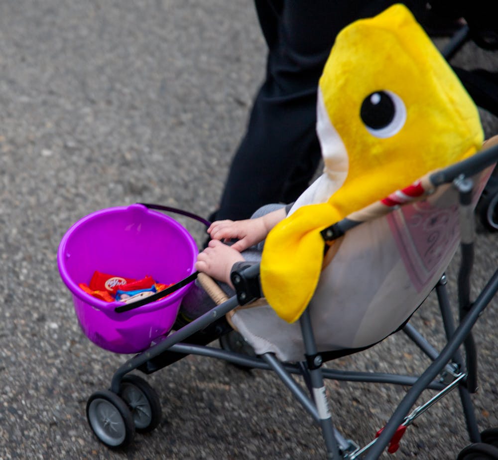 <p>M.A.C. Avenue and surrounding streets in East Lansing were closed off for Safe Halloween on Oct. 27, 2021. Shown is a baby shark holding a bucket for candy. </p>