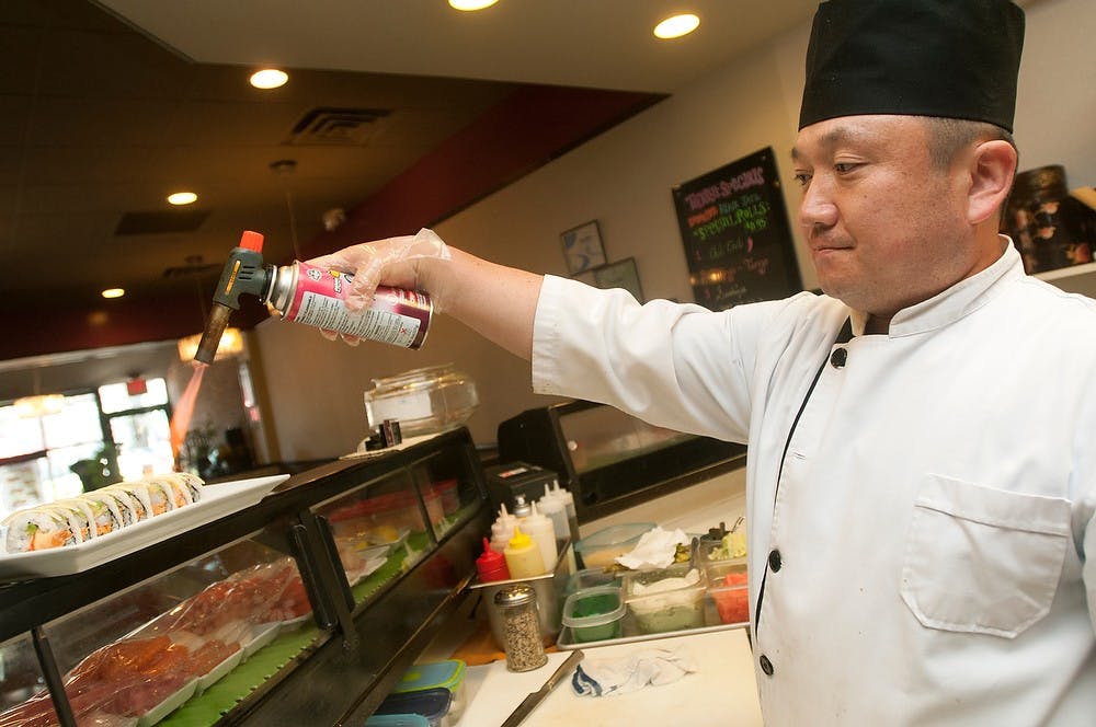 	<p>East Lansing resident Shawn Ko puts a blow torch to a waikki dish Aug. 9, 2013, at Sushi Ya, 529 E. Grand River Ave. Ko has been a sushi chef for the past 15 years. Weston Brooks/The State News</p>