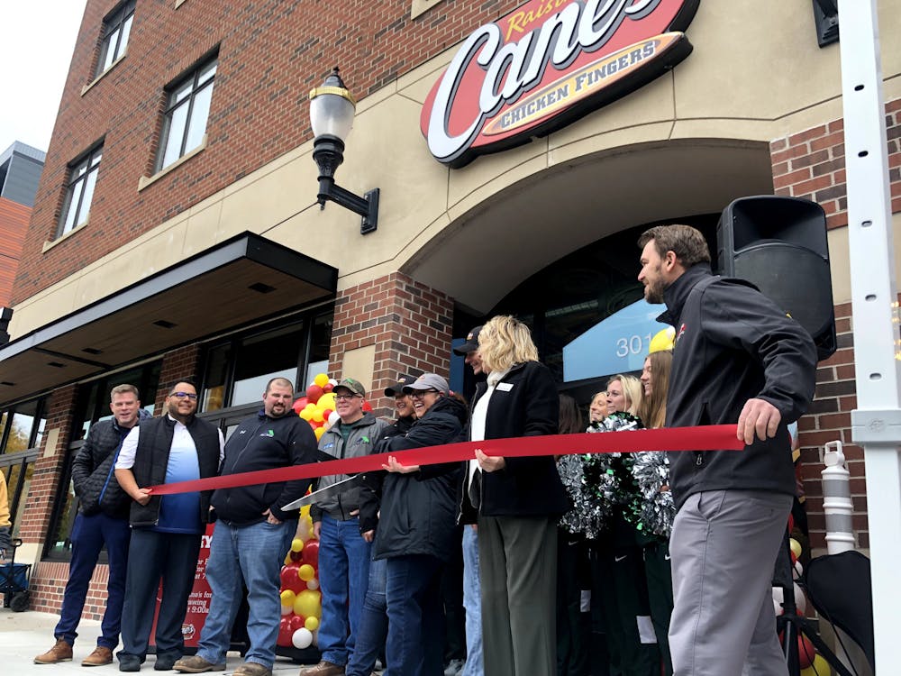 <p>East Lansing community members and Raising Cane&#x27;s staff cut the ribbon of their first Michigan location on Oct. 18, 2022.</p>