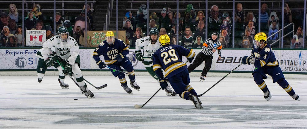 Sophomore forward Jagger Joshua (23) skates the puck down the ice towards Notre Dame's goal during the second period. The Fighting Irish shutout the Spartans 2-0 on Feb. 27, 2021.