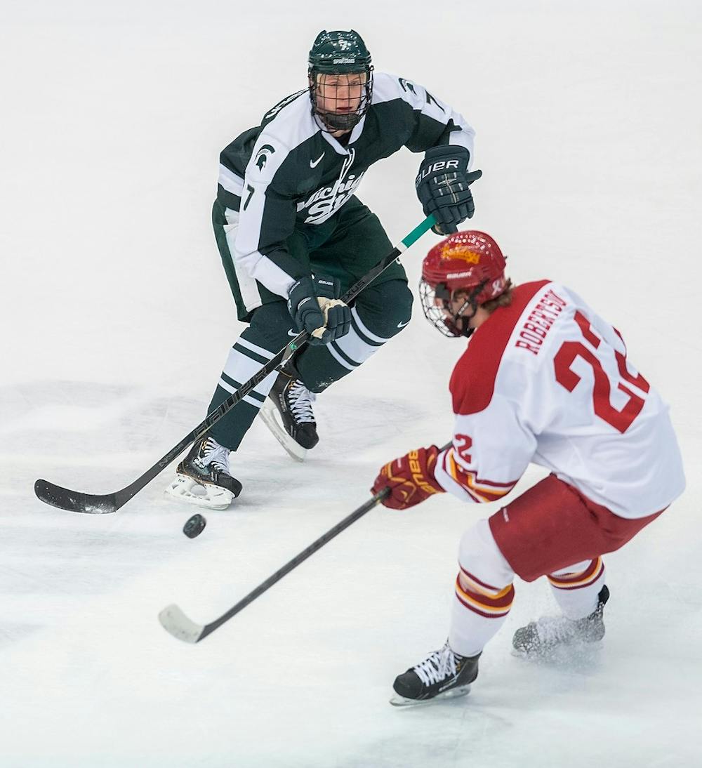 	<p>Freshman defenseman John Draeger moves the puck with Ferris State forward Matt Robertson in defense. The Bulldogs defeated the Spartans, 2-1, Friday, Jan. 18, 2013, at Munn Ice Arena. Justin Wan/The State News</p>
