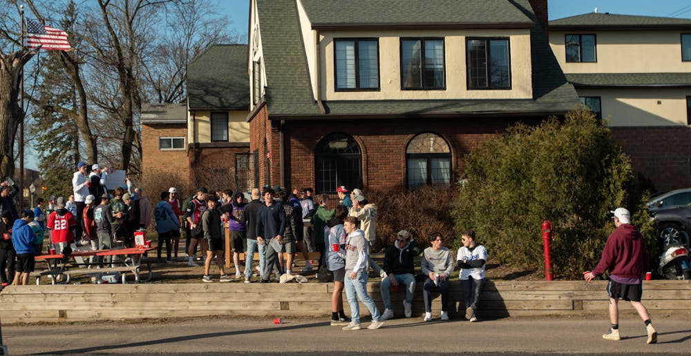 People drinking outside of a frat house on March 13, 2021.
