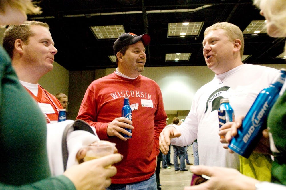 From right, Bill Gont, of Chicago, Brad Cook of Milwaukee, Wis., and Jason Cook of St. Louis, carry a conversation at the Spartan Nation Pep Rally for the 2011 Big Ten Championship Game Saturday afternoon at Indiana Convention Center, in Indianapolis. Justin Wan/The State News