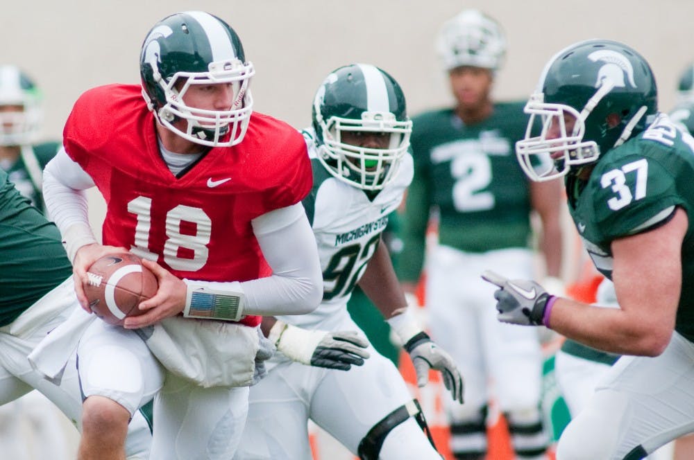 Redshirt freshman Connor Cook about to hand in the ball to junior running back Le'Veon Bell during the annual Spring Game on Saturday afternoon at Spartan Stadium. The White team defeated the Green team, by 14-2. Justin Wan/The State News