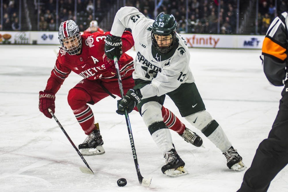 Junior left wing Brennan Sanford (13) handles the puck during the first period of the men's hockey game against Ohio State on Jan. 5, 2018 at the Munn Ice Arena. (Nic Antaya | The State News)