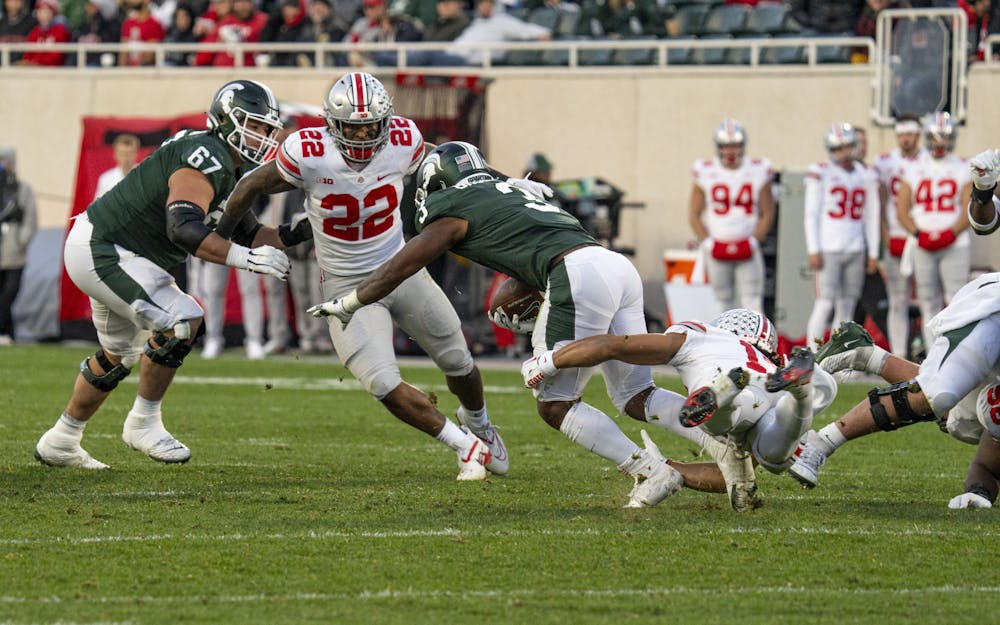 <p>Fifth-year running back Jarek Broussard, 3, is tackled during Michigan State’s game against Ohio State on Saturday, Oct. 8, 2022 at Spartan Stadium. The Buckeyes ultimately beat the Spartans, 49-20.</p>