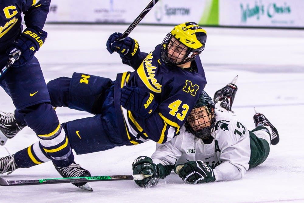 Senior forward Brennan Sanford (13) dives to the ice during the game against Michigan Nov. 30. The Spartans defeated the Wolverines, 4-3.