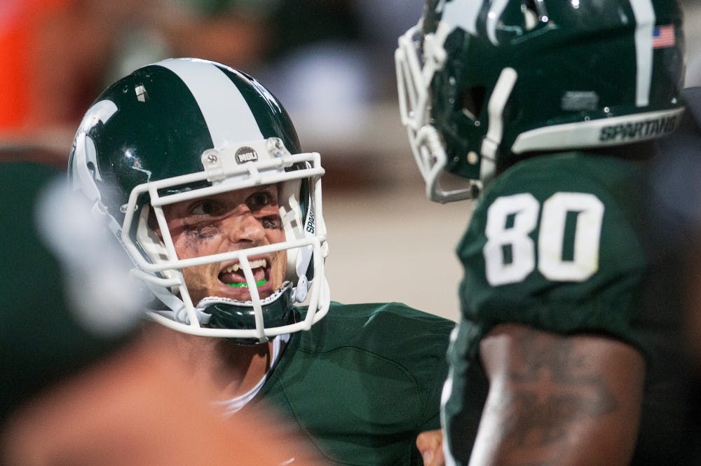 Junior quarterback Andrew Maxwell celebrates with junior tight end Dion Sims after scoring a touchdown Friday night, Aug. 31, 2012 at Spartan Stadium. Maxwell threw for 248 yards during a 17-13 win against Boise State in MSU's home opener. Adam Toolin/The State News