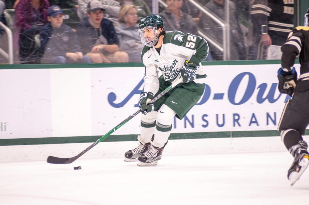 Sophomore defender Mitch Eliot (52) brings the puck up the ice during the game against Western Michigan on Oct. 20, 2017, at Munn Ice Arena. The Spartans defeated the Broncos 6-4.