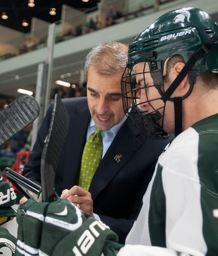 	<p>Head coach Tom Anastos goes over a play with senior forward Dean Chelios during a timeout in the game against Minnesota on Dec. 6, 2013, at Munn Ice Arena. The Spartans tied the game with the Golden Gophers, 2-2, but won the shootout. Danyelle Morrow/The State News</p>