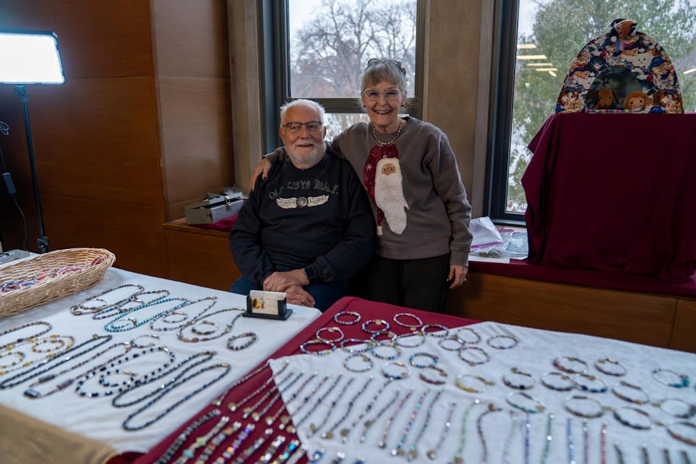 Estelle and Robert Williams pose for a picture at their table during Michigan State’s annual winter arts and craft show at the Union on campus in East Lansing, Mich., on Saturday, Dec. 6, 2025. “We’ve been doing this about 27 years now, my wife started it and I joined her later,” Robert said. “We make all of this jewelry by hand,” Estelle said.