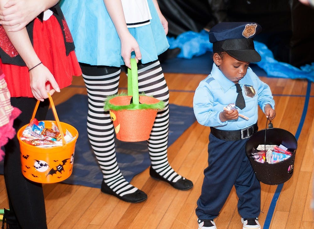 One-year-old Noah Adkins collects candy from West Circle residents in Gilchrist Pub on Tuesday, 30 Oct., 2012 during West Circle's safe Trick-or-Treating event. The event was hosted in order to provide local kids with a safer opportunity to trick-or-treat this year. Danyelle Morrow/The State News