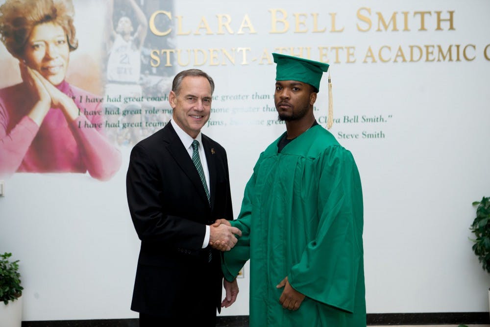 <p>MSU football head coach congratulates football player Myan Hicks after receiving his diploma. &nbsp;Photo courtesy of MSU Athletic Communications.</p>