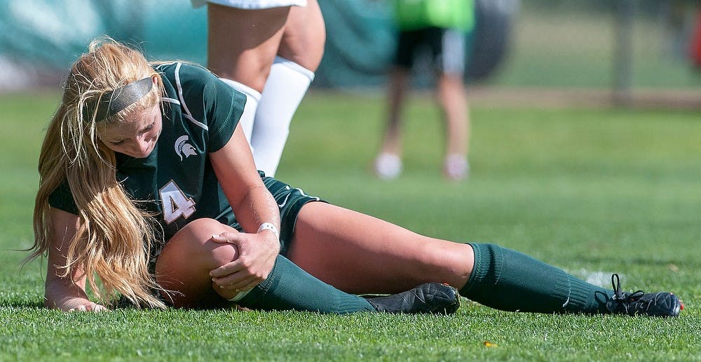 	<p>Then-sophomore forward and midfielder Lisa Vogel lies injured Sept. 30, 2012, during the game against Iowa at DeMartin Stadium at Old College Field. The Spartans tied with the Hawkeyes, 0-0. State News File Photo</p>