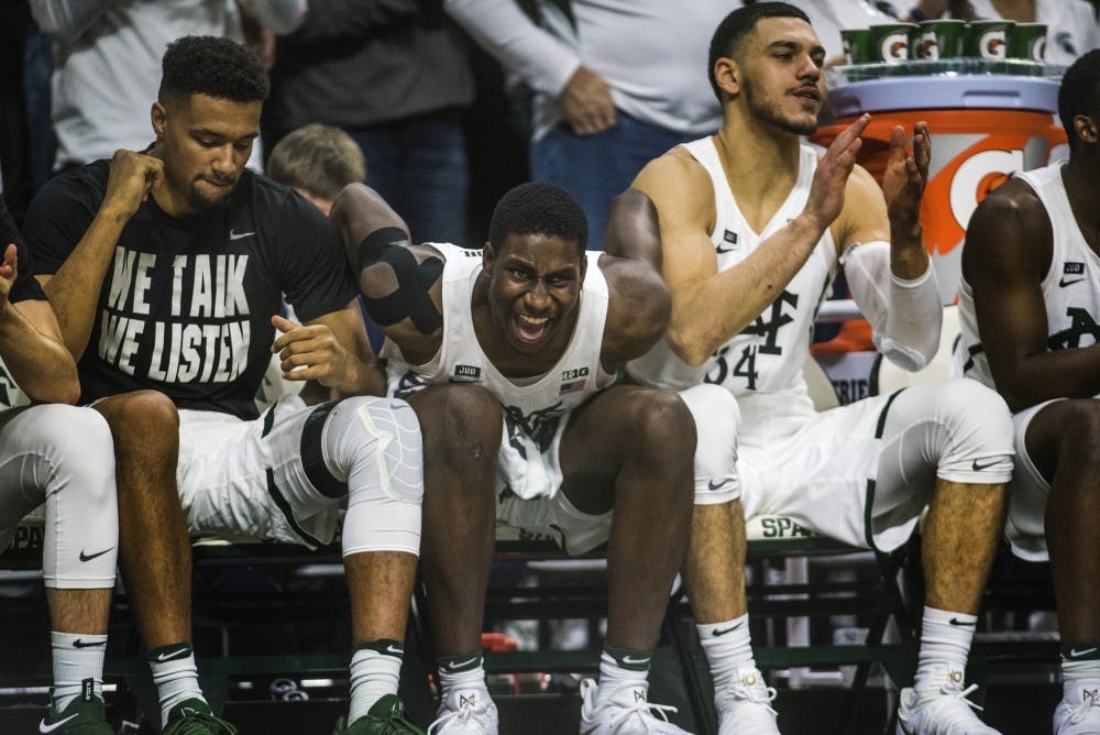 From left to right, redshirt junior forward Kenny Goins (25), freshman forward Jaren Jackson Jr. (2) and redshirt senior forward Gavin Schilling (34) react to a play during the game against Notre Dame on Nov. 30, 2017 at Breslin Center. The Spartans took down the Fighting Irish, 81-63. 