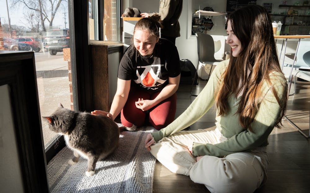 <p>MSU students McKenzie Wilson (left) and Zoëy Potts visit with a cat named Earl Grey at Constellation Cat Cafe on Wednesday, March 15, 2023. The Cafe, located at 3320 E Lake Lansing Rd, East Lansing, allows patrons to visit with a roomful of cats for an hour for $14 per person. The price includes a drink.</p>
