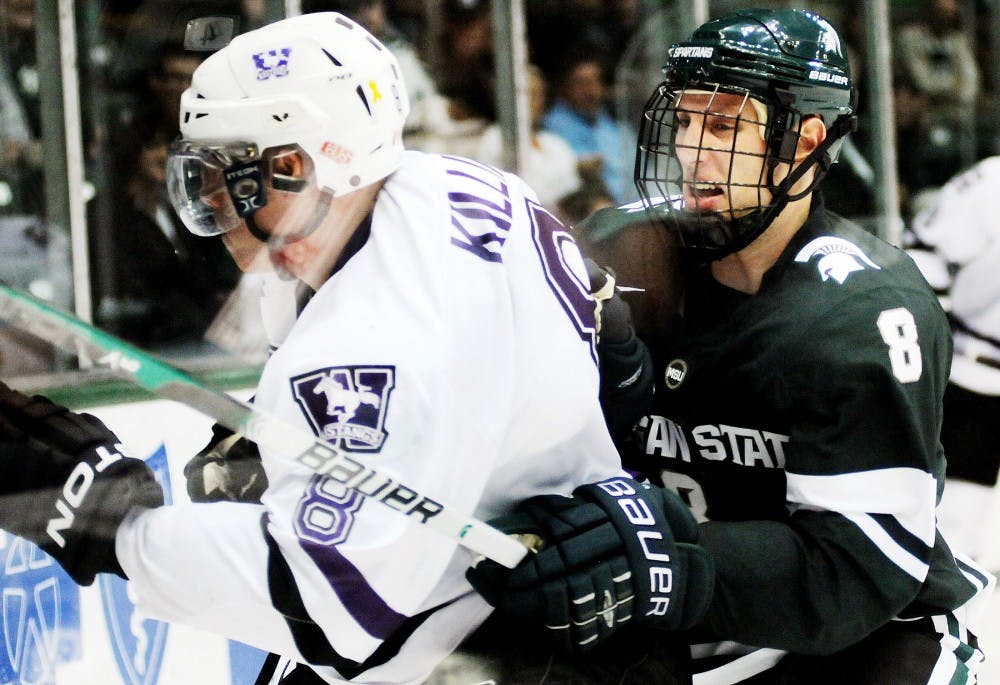 Junior forward Chris Forfar checks Western Ontario defensman Geoff Killing into the boards. The Spartans defeated Western Ontario, 6-1, on Monday night at Munn Ice Arena. The game was Tom Anastos' first time leading the Spartans on the ice after former head coach Rick Comley resigned after last season. Josh Radtke/The State News