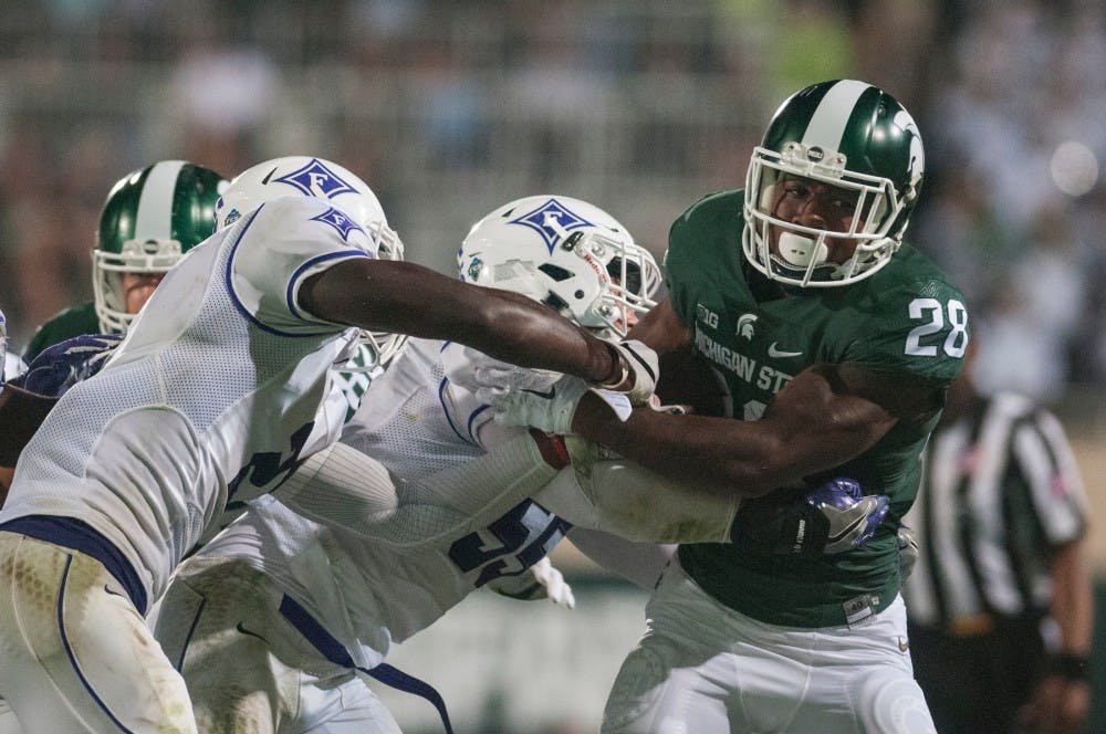 From left, Furman safety Trey Robinson (2) and Furman linebacker Carl Rider (55) wrap up sophomore running back Madre London (28) during the home football game against Furman on Sept. 2, 2016 at Spartan Stadium. The Spartans defeated the Paladins, 28-13.