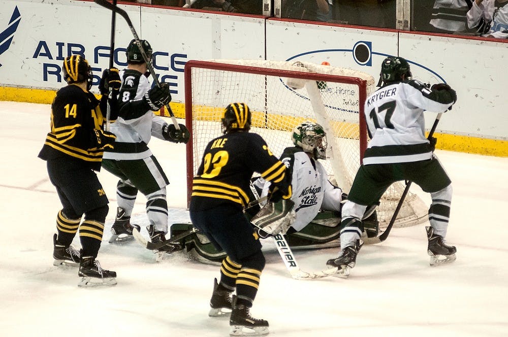 <p>Junior goaltender Jake Hildebrand blocks the puck from entering the goal March 20, 2015, during the Big 10 Hockey Tournament at Joe Louis Arena. The Spartans lost to the Wolverines, 4-1. Allyson Telgenhof/The State News.</p>