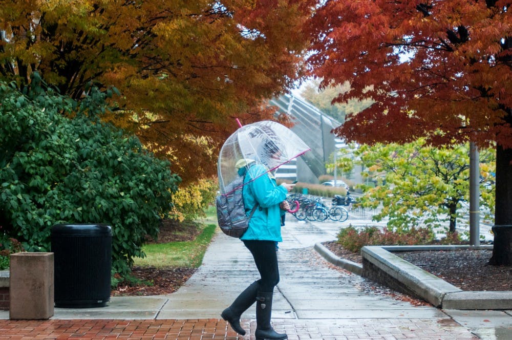 <p>A student leaves Berkey Hall in October 2013. According to PureMichigan.com, mid to late October is the best time to see the fall colors in the lower peninsula. </p>