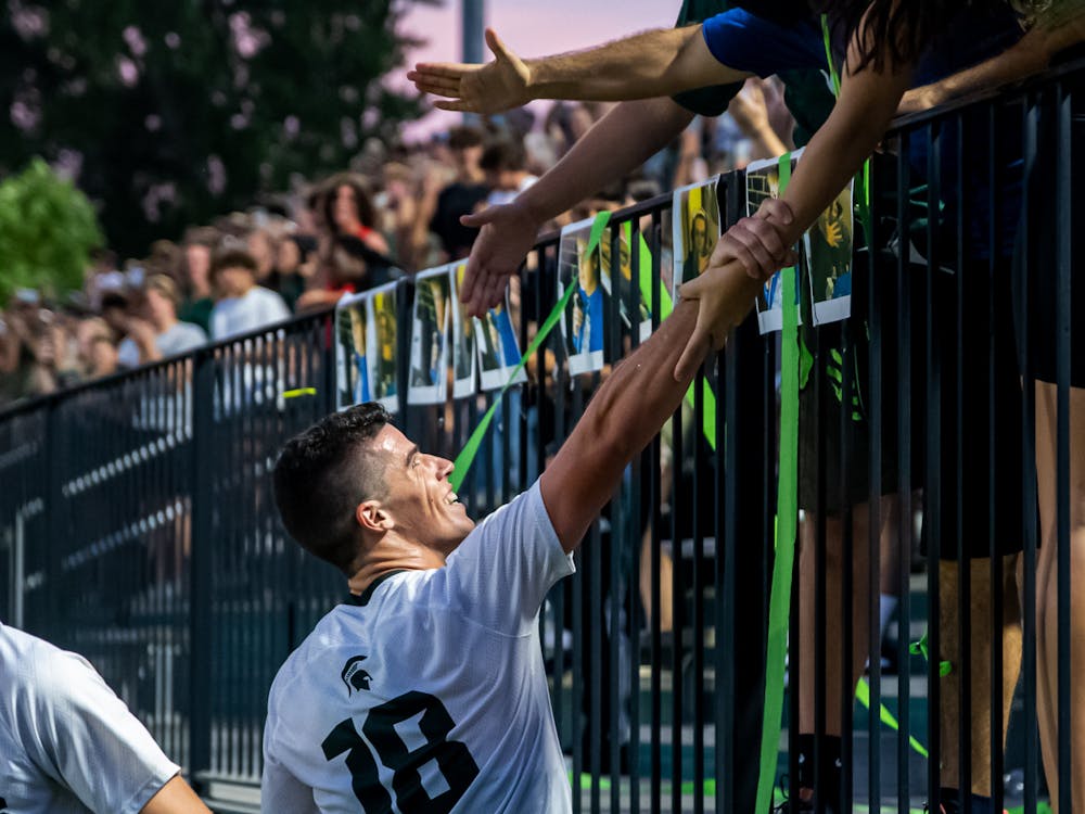 <p>Graduate student midfielder Michael Miller embraces with the stands, following his goal on Aug. 30, 2021.</p>