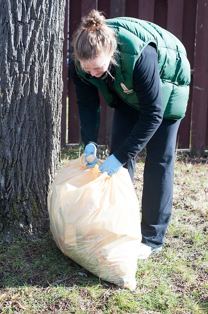 	<p>Community Relations Coalition, or <span class="caps">CRC</span>, intern and international relations senior Hannah Champ ties up her bag of collected trash Nov. 3, 2013, on the corner of Linden Street and Park Lane. The <span class="caps">CRC</span> teamed up with the Panhellenic and Interfraternity councils to clean up the aftermath of the weekend&#8217;s game on the streets of East Lansing. Margaux Forster/The State News</p>