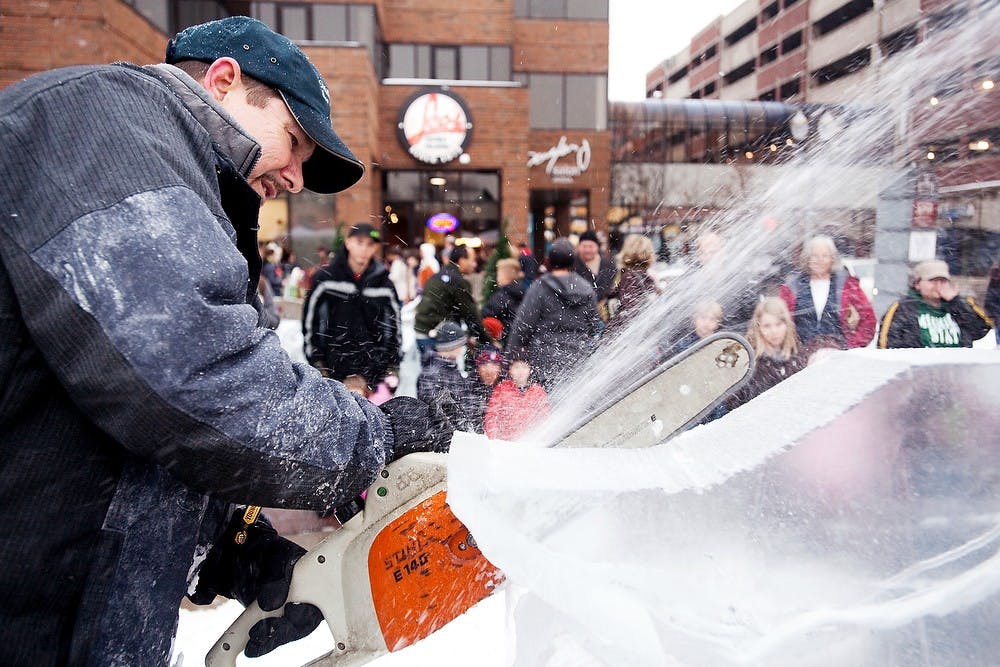 	<p>Lansing resident Scott Miller uses a chainsaw to carve away at a large block of ice Dec. 2, 2011, at Winter Glow in downtown East Lansing. The event gave East Lansing residents the opportunity to get into the holiday spirit with food, performances and carriage rides. State News File Photo</p>