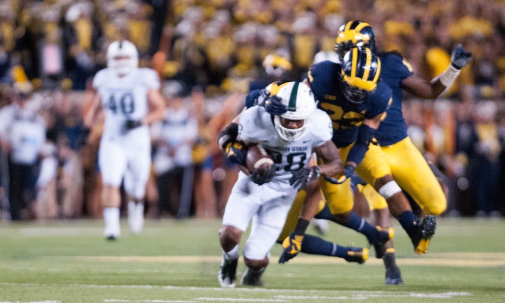 <p>Senior running back Madre London (28) is tackled by Michigan defensive back Tyree Kinnel (23) during the game against University of Michigan on Oct. 7, 2017, at Michigan Stadium. The Spartans defeated the Wolverines 14-10.</p>