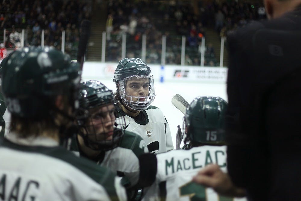	<p>Sophomore forward Michael Ferrantino, center, listens to head coach Tom Anastos during a break in play against Ohio State on Feb. 7, 2014, at Munn Ice Arena. The Spartans tied with the Buckeyes, 2-2, and lost the shootout. Danyelle Morrow/The State News</p>