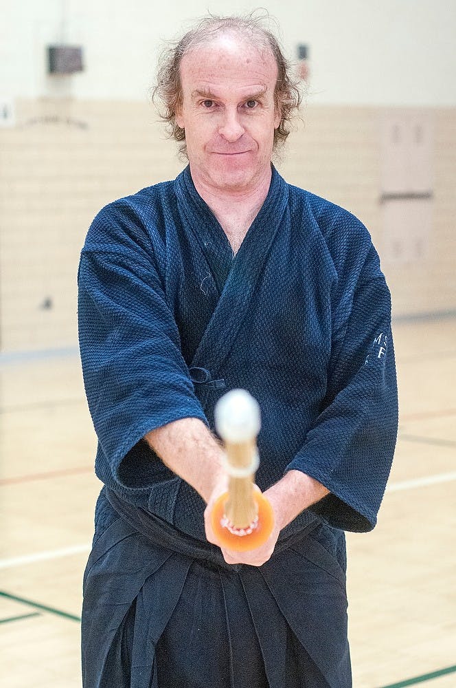 <p>MSU alumn and Senior Physicist at the National Superconducting Cyclotron Laboratory Ron Fox poses for a portrait with his shinai Feb. 9, 2015, in the IM Sports-Circle gymnasium. Fox started practicing kendo in college and now volunteers instructing KIN 102M, Kendo I. Kelsey Feldpausch/The State News</p>