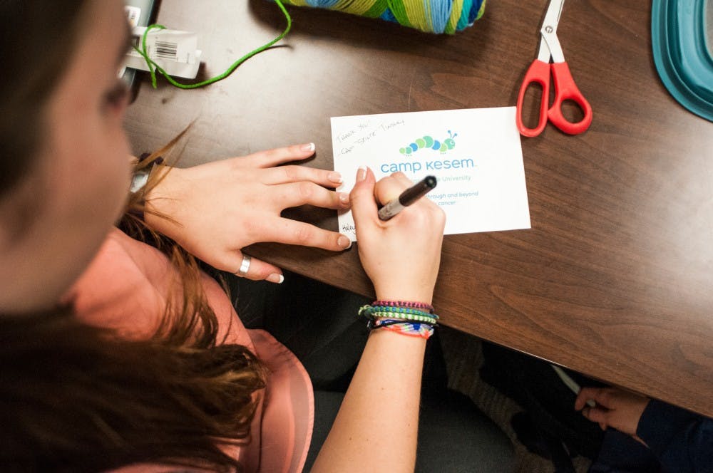 <p>Education senior Haley Gumenick signs a card of gratitude during the Camp Kesem Coordinator Meeting on April 24, 2017 at Erickson Hall. Gumenick is a director and counselor at the camp. Camp Kesem is an annual summer camp put on by MSU students for individuals ages 7-17 whose parents have been affected by cancer.&nbsp;</p>