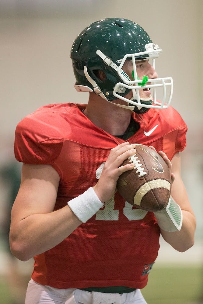 <p>Junior quarterback Connor Cook looks to throw the ball during football practice April 15, 2014, at the practice field inside the Duffy Daugherty Football Building. Julia Nagy/The State News</p>