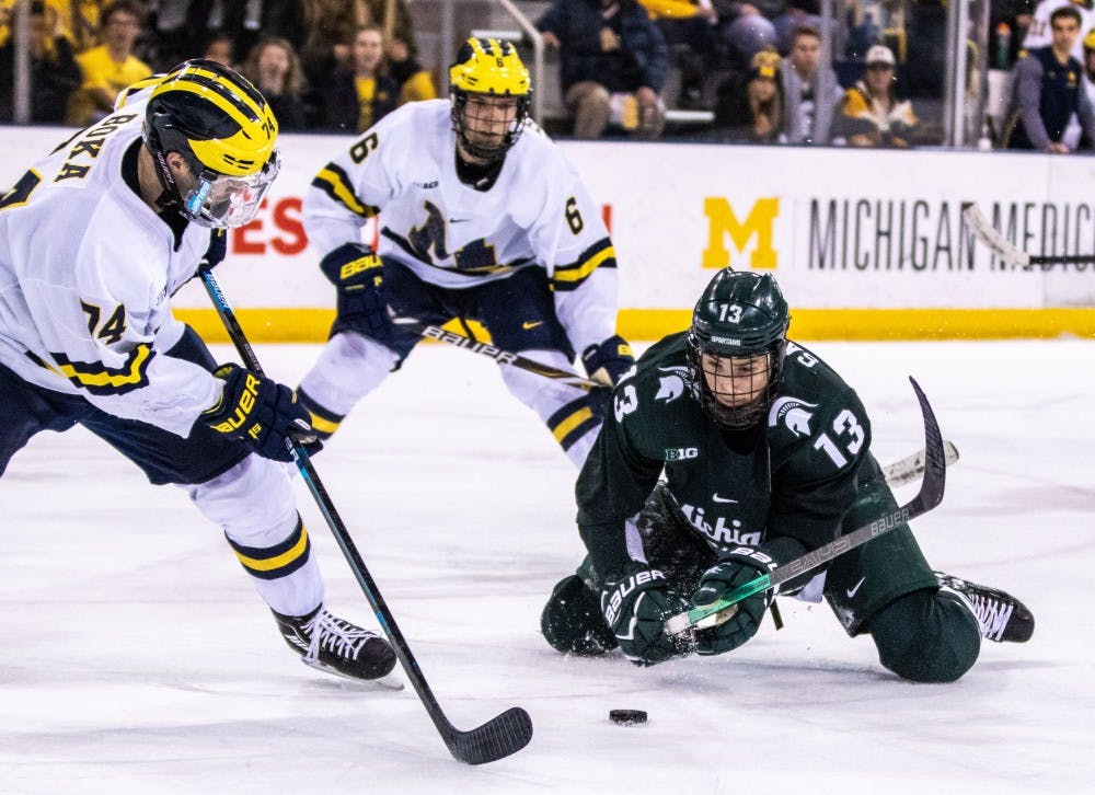 Senior forward Brennan Sanford (13) swings at the puck from his knees during the game against Michigan Feb. 9 at Yost Ice Arena. The Spartans fell to the Wolverines, 5-3.