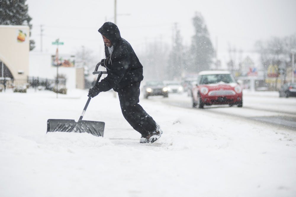 Lansing resident Ellington Fields shovels snow during a  snow storm on Mar. 1, 2016 on Grand River Ave. 