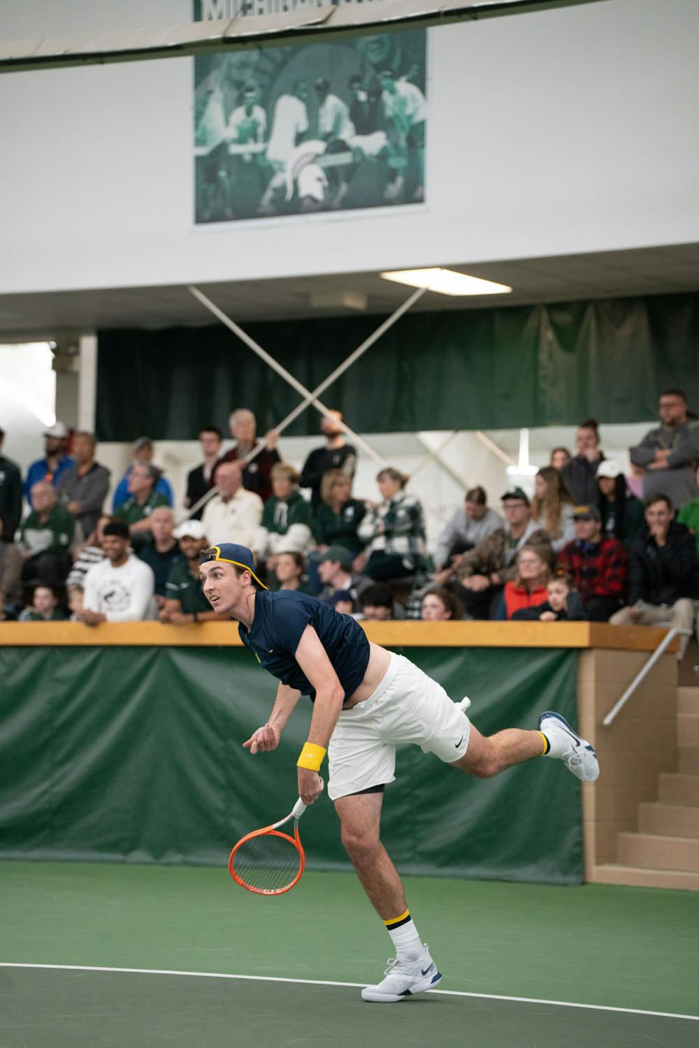 <p>Michigan junior Nino Ehrenschneider returns the ball during his doubles match with fifth-year Patrick Maloney against Michigan State at the MSU Tennis Center on March 30, 2023. The Spartans lost to the Wolverines 6-1.</p>