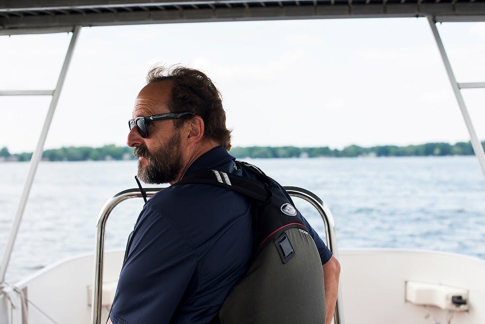 <p>Sport Facility Professional with the Department of Recreational Sports and Fitness services Ken Warshaw steers a boat June 26, 2014, on Lake Lansing. Warshaw has held his position for over 18 years. Hayden Fennoy/The State News</p>