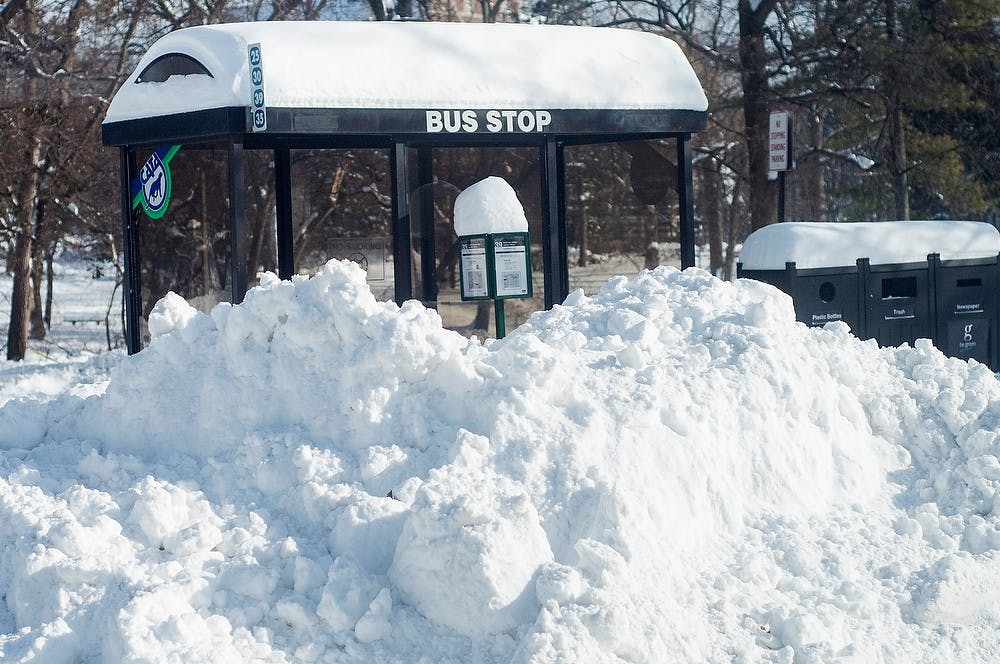 	<p>Snow is piled high at a <span class="caps">CATA</span> bus stop Jan. 7, 2014, outside of Wells Hall. Despite the class cancellations and the weather, buses continued to run. Erin Hampton/ The State News</p>