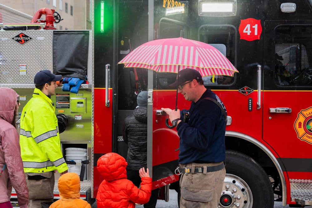 <p>A young boy waves to a firefighter at an Easter egg hunt on the Capitol lawn in Lansing, MI, on Saturday, March 30, 2024. Firefighters helped kids climb into the truck and take a look around.</p>