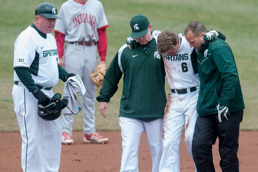 	<p>Head coach Jake Boss Jr., left, watches as senior outfielder Jordan Keur is helped off the field April 12, 2013, during the first game of a three game series against Indiana at McLane Baseball Stadium at Old College Field. Keur tore his <span class="caps">ACL</span> as he was running to second base. Julia Nagy/The State News</p>