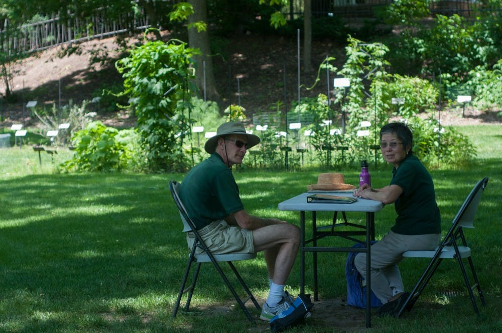 East Lansing resident Steve Davis, left, and Okemos resident Emily Tseng volunteer as garden ambassadors on June 11, 2016 at the Beal Botanical Garden. Davis and Tseng said that they enjoy the scenery as well as the variety of visitors the garden gets.