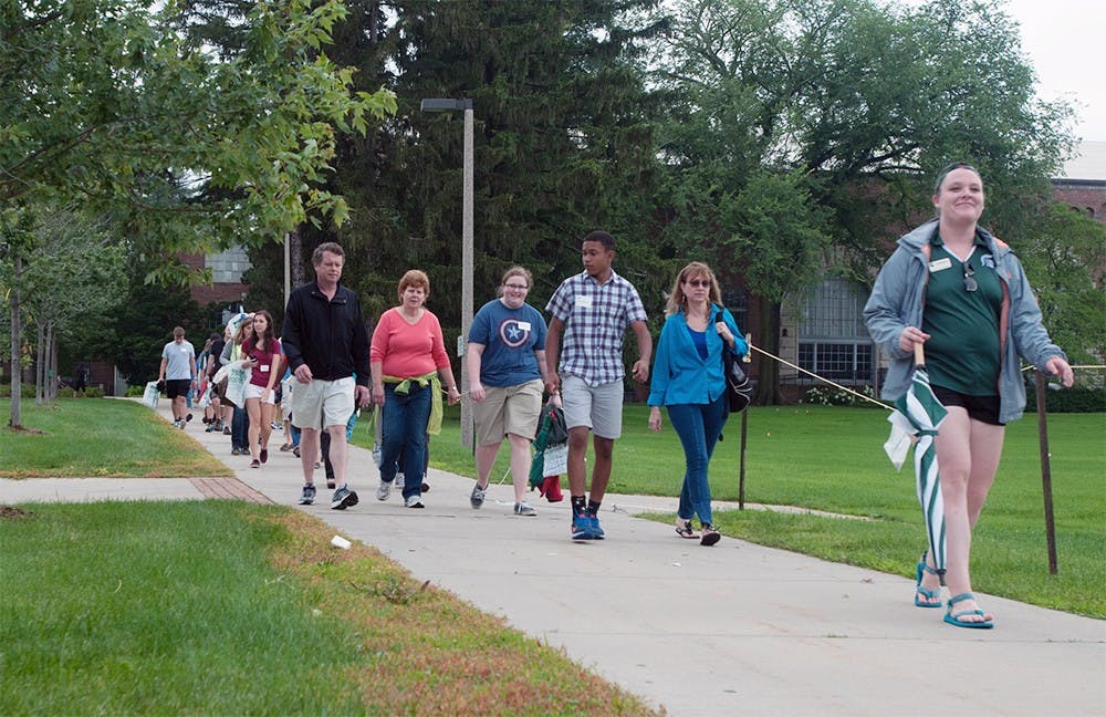 <p>An AOP leader gives a tour of MSU to a group of incoming students and their parents July 7, 2015 on Chestnut Road. Catherine Ferland/ The State News </p>