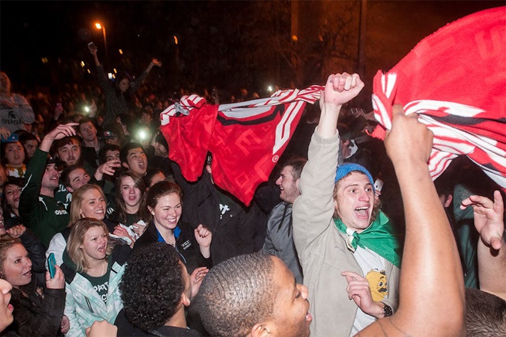 <p>Student tear apart an Ohio State flag during a riot in the streets of Cedar Village after an MSU victory in the Big Ten Championship game on Dec. 8, 2013. The police and fire department are responded to multiple riots and fires across East Lansing. State News File Photo</p>