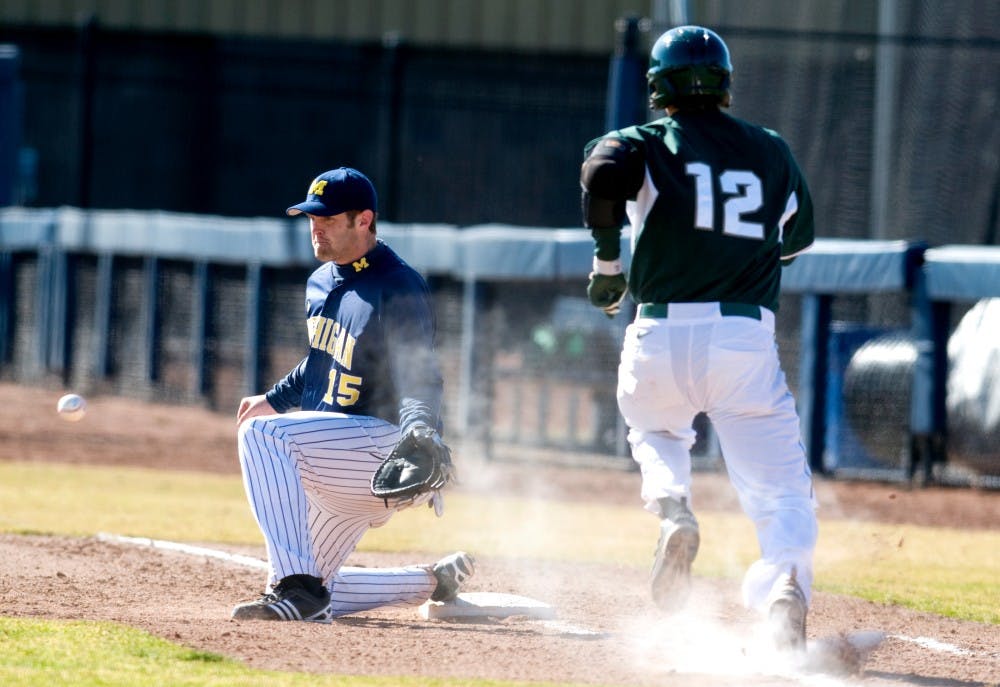 Sophomore third baseman Andrew Carpenter races to beat a throw headed towards Michigan first baseman Garrett Stephens Sunday at Ray Fisher Stadium at Wilpon Baseball Complex in Ann Arbor. The Spartans defeated the Wolverines, 8-2, to sweep their instate rivals in this weekend's series. Matt Radick/The State News