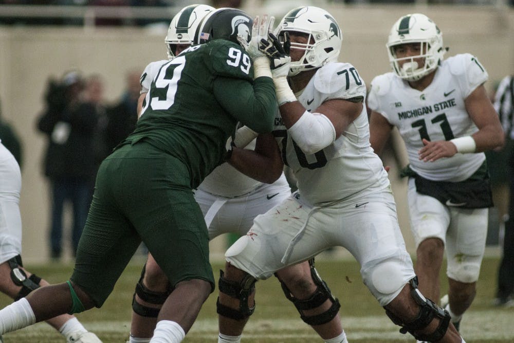 Redshirt junior guard Tyler Higby (70) blocks redshirt junior defensive tackle Reaquan Williams (99) during the annual Green and White spring game on April 7, 2018 at Spartan Stadium. White beat Green 32-30. (C.J. Weiss | The State News)