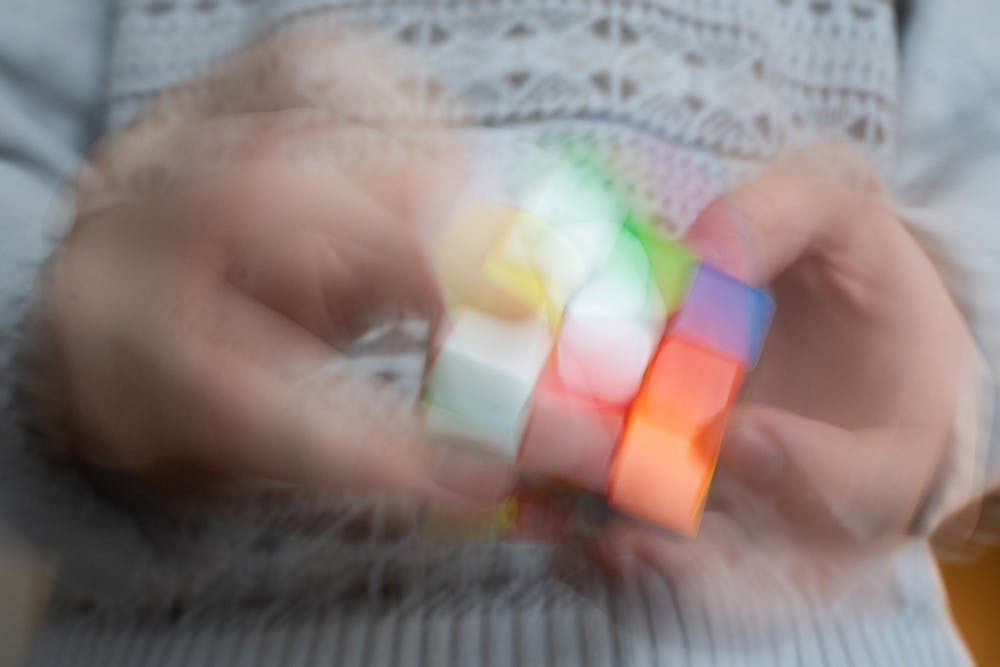 <p>Colors blue as experience architecture senior Owen Widdis, 22, scrambles his Rubik’s Cube in his home in East Lansing on Sunday, Feb. 18, 2024. Widdis reckons he can scramble the cube at 13 or 14 turns per seconds, or TPS, creating a blurred rainbow.</p>