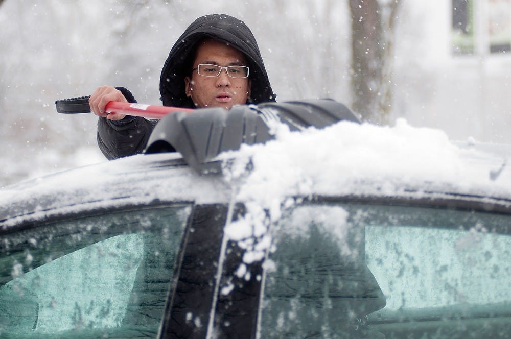 	<p>Economics senior Kevin Cho shovels snow off of a rented car Jan. 5, 2014, in front of the Abrams Planetarium. Cho spent about a half hour cleaning the car. Christina Strong/The State News </p>