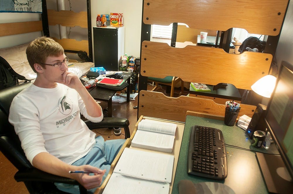 	<p>General management sophomore Austin Dickerson takes notes while viewing a slideshow for a hybrid philosophy class Wednesday in his West Shaw Hall dorm room. Dickerson said the class meets once a week in person. Danyelle Morrow/The State News</p>