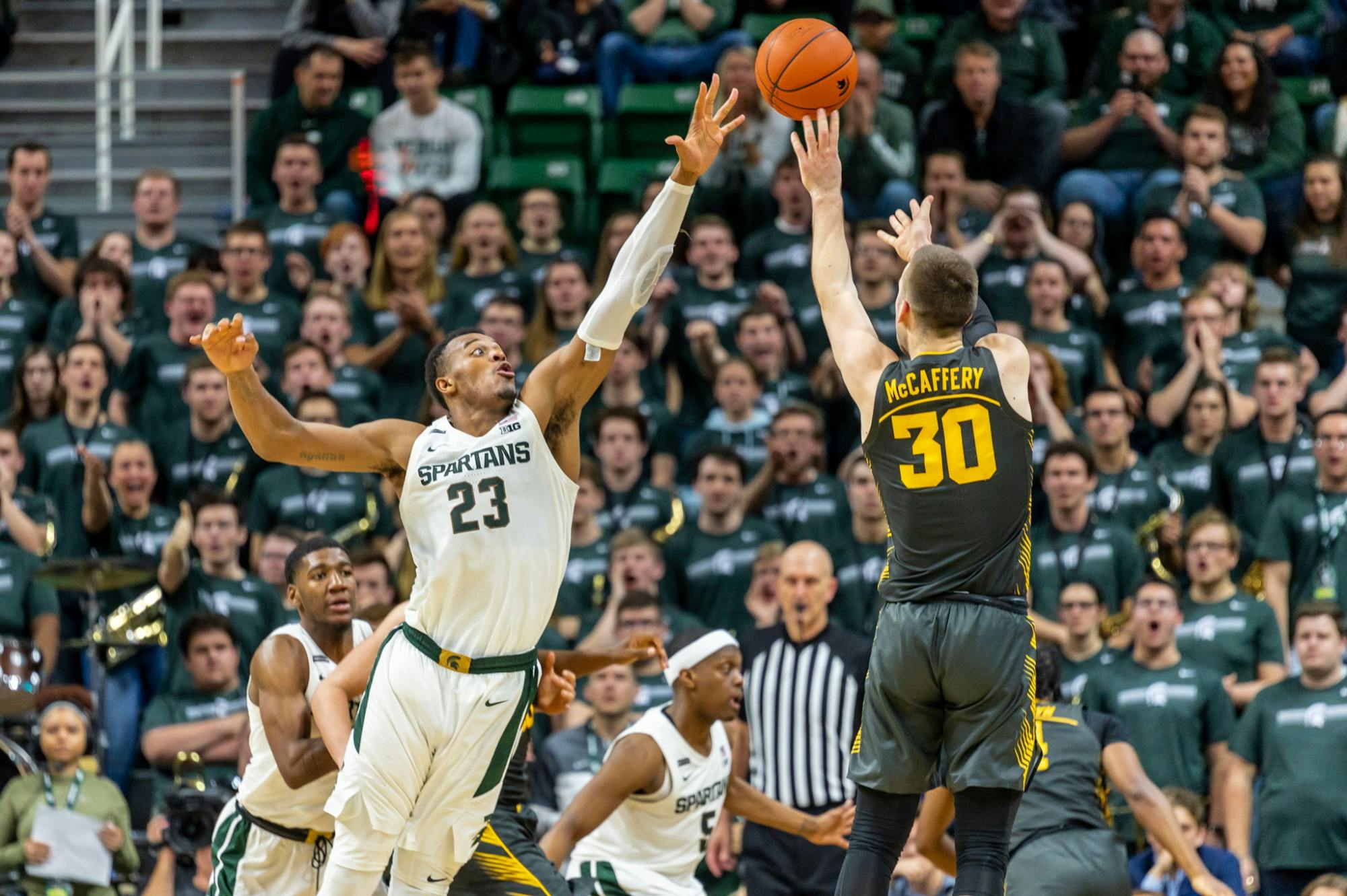 <p>Iowa guard Connor McCaffery (30) shoots over junior forward Xavier Tillman Sr. (23). The Spartans defeated the Hawkeyes, 78-70, at the Breslin Center on Feb. 25, 2020. </p>